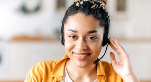 Image of a woman wearing a headset and smiling directly at the camera