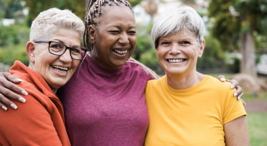 Image of 3 women standing together with arms around each other smiling