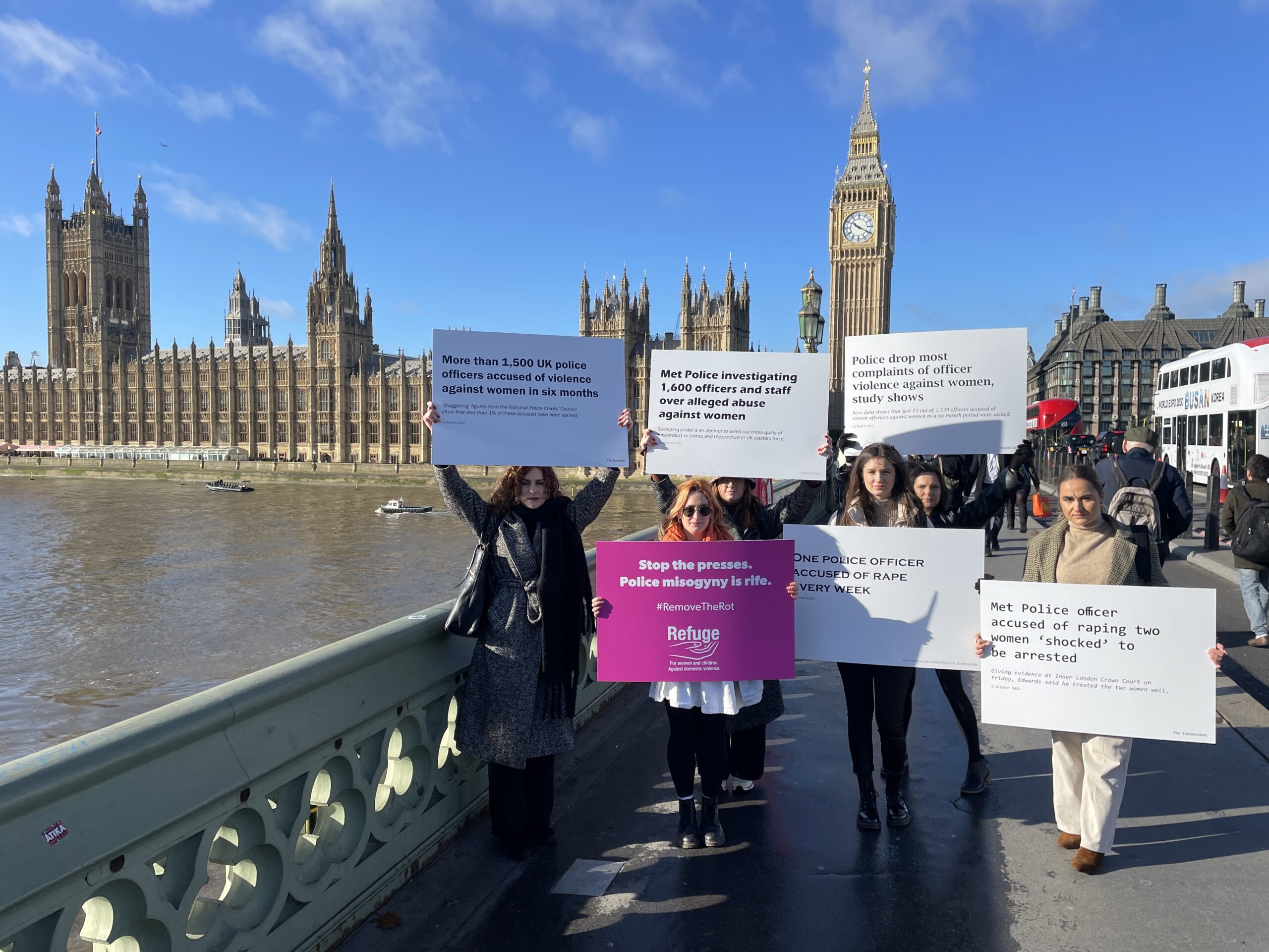 Image of staff outside parliament holding placards with headlines relating to police perpetrated abuse.