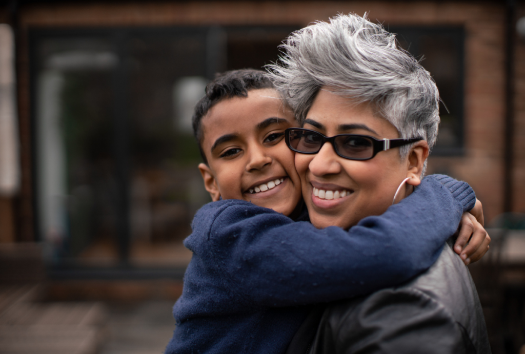 Mother and son hugging and looking at camera