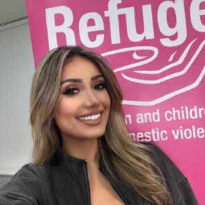 Nikita Kanda selfie in front of pink Refuge banner