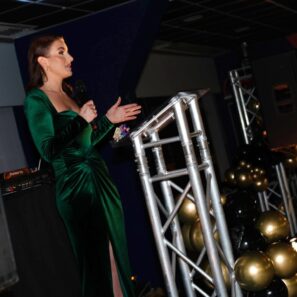 Person standing at Gala podium speaking to audience