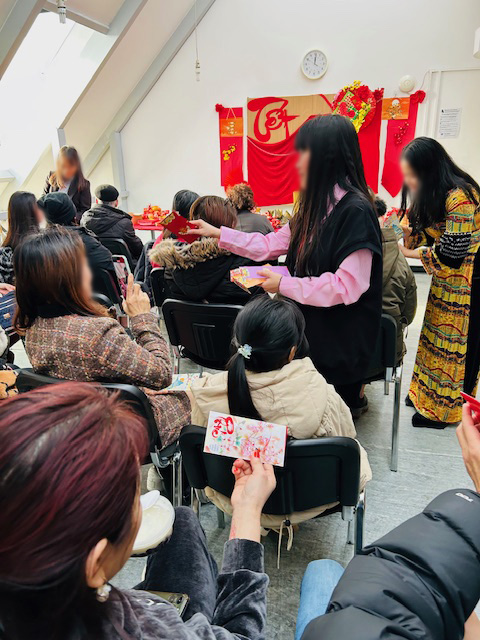 A group of women sharing food with Lunar New Year decorations in the background