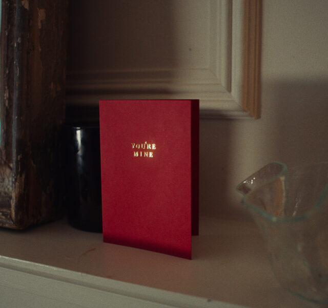 Red card on mantle piece reading 'You're mine' in gold text