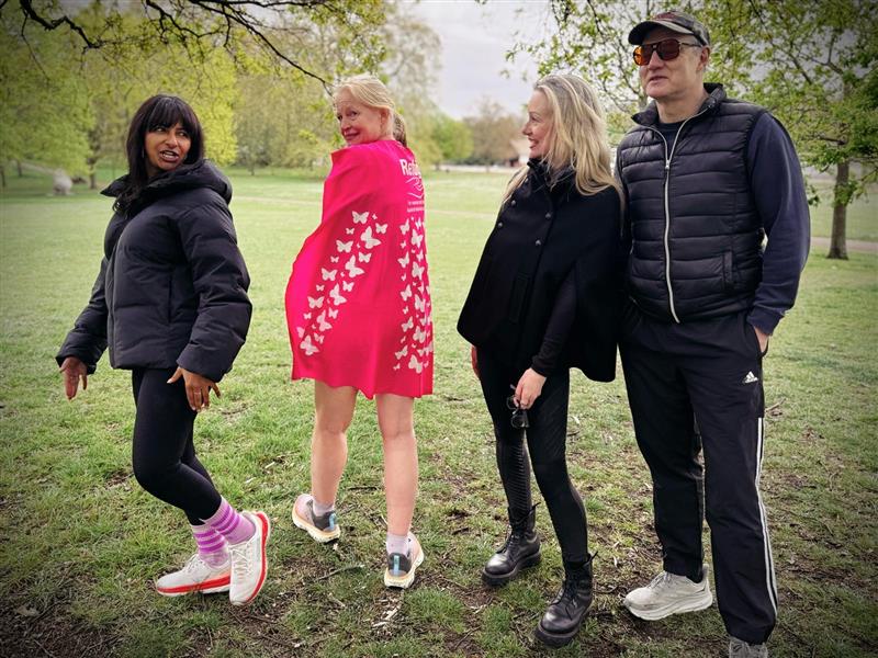 Refuge ambassadors stand alongside Hetti in a park in running gear. hetti is wearing a pink cape with butterflies.