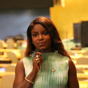 Portrait of Eni Aluko, hand resting under her chin, smiling