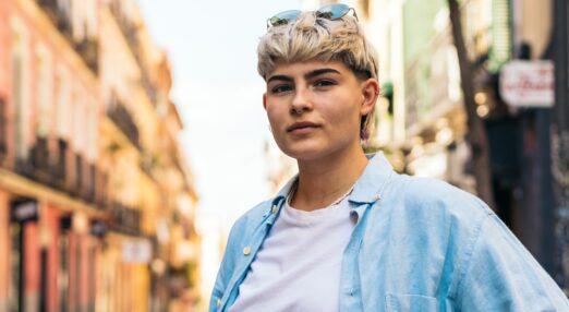 portrait of woman with short hair and nose ring, stood outside on the street